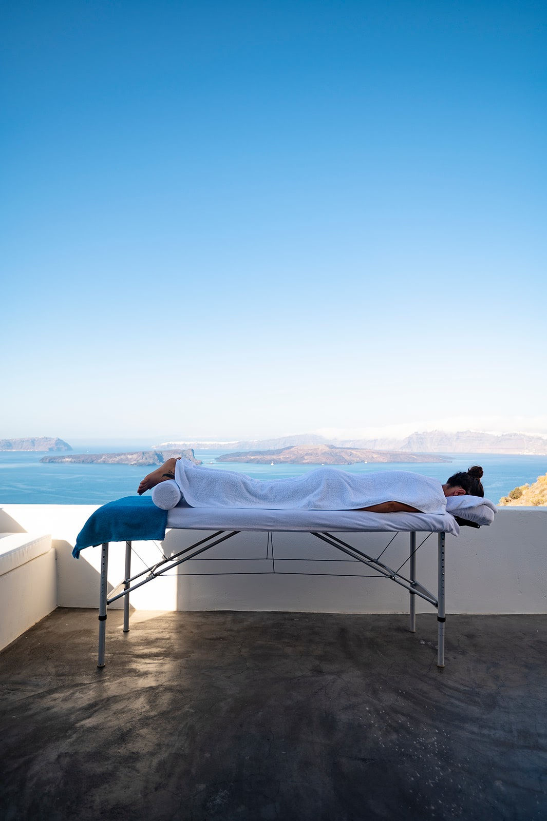 Embrace Serenity: Post Anti-Stress Massage Bliss with a Calm Woman against the Azure Seascape of Santorini