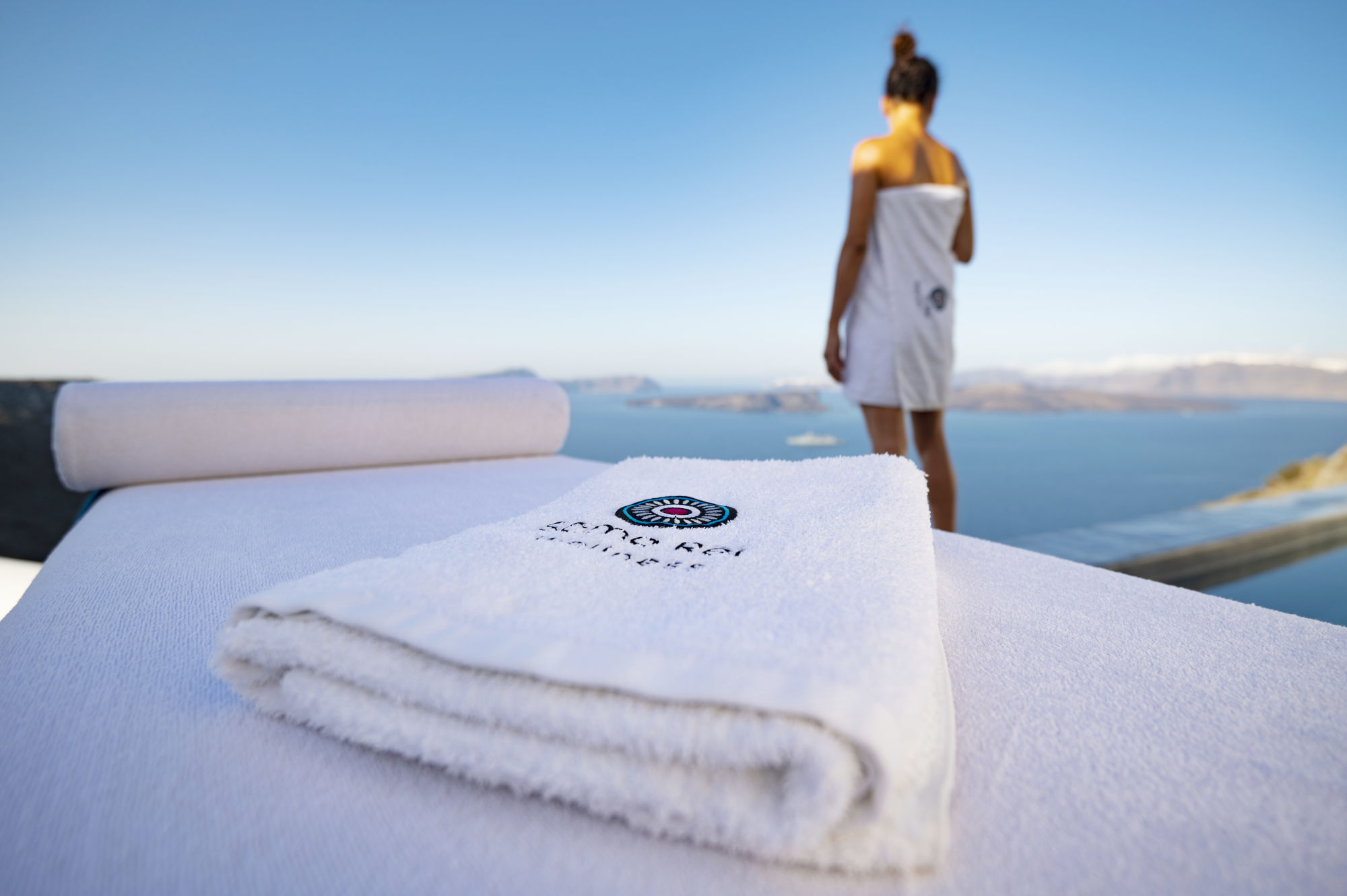 Woman enjoying the serene caldera view post Anti Stress Massage Treatment by Soma Rei Wellness in Santorini.