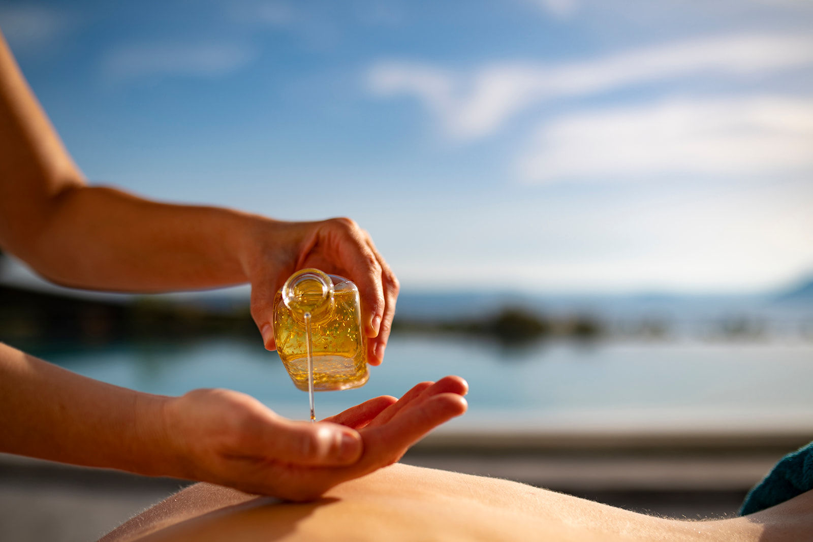 Herbal Oil Massage: Therapist holding a droplet of nourishing herbal oil, a blend of organic olive oil and essential oils.