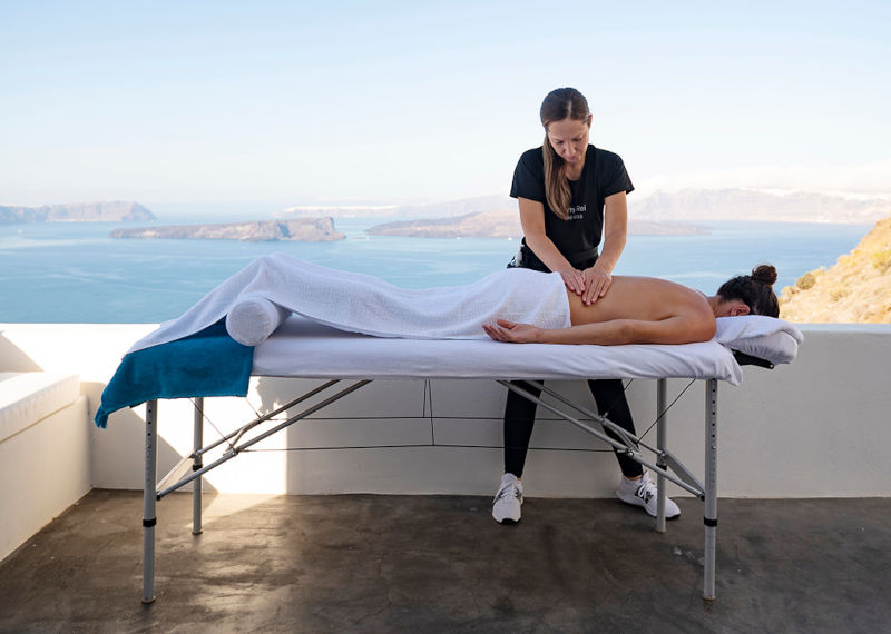 Santorini Mobile Massage: Personalized Relaxation treatments in Santorini for a woman with a stunning sea and volcano view at Akrotiri